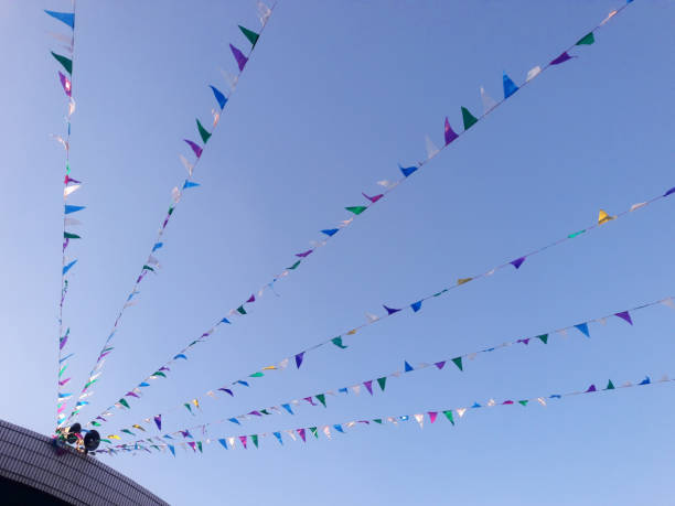 istock Colorful triangular bunting flags waving on the blue sky outdoors. Pennants of various colors fluttered in the sky. Abstract festive background, outdoors 1448739987