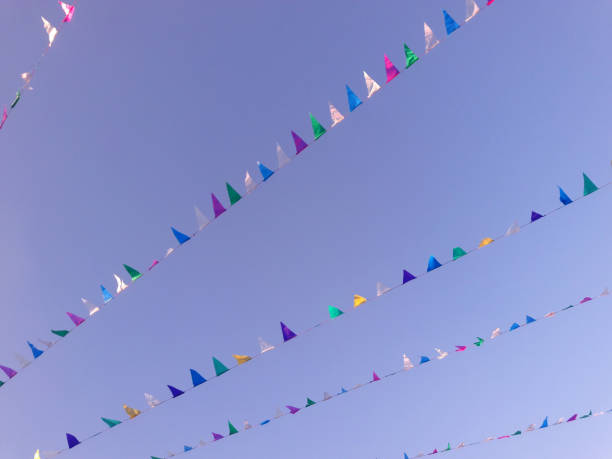 istock Colorful triangular bunting flags waving on the blue sky outdoors. Pennants of various colors fluttered in the sky. Abstract festive background, outdoors 1448739988