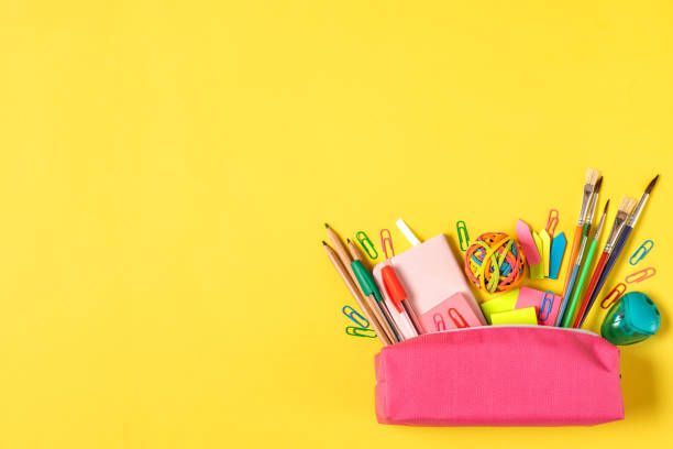 istock Back to school concept. Pencil case with various school stationery items on bright yellow background with copy space top view 1448740108