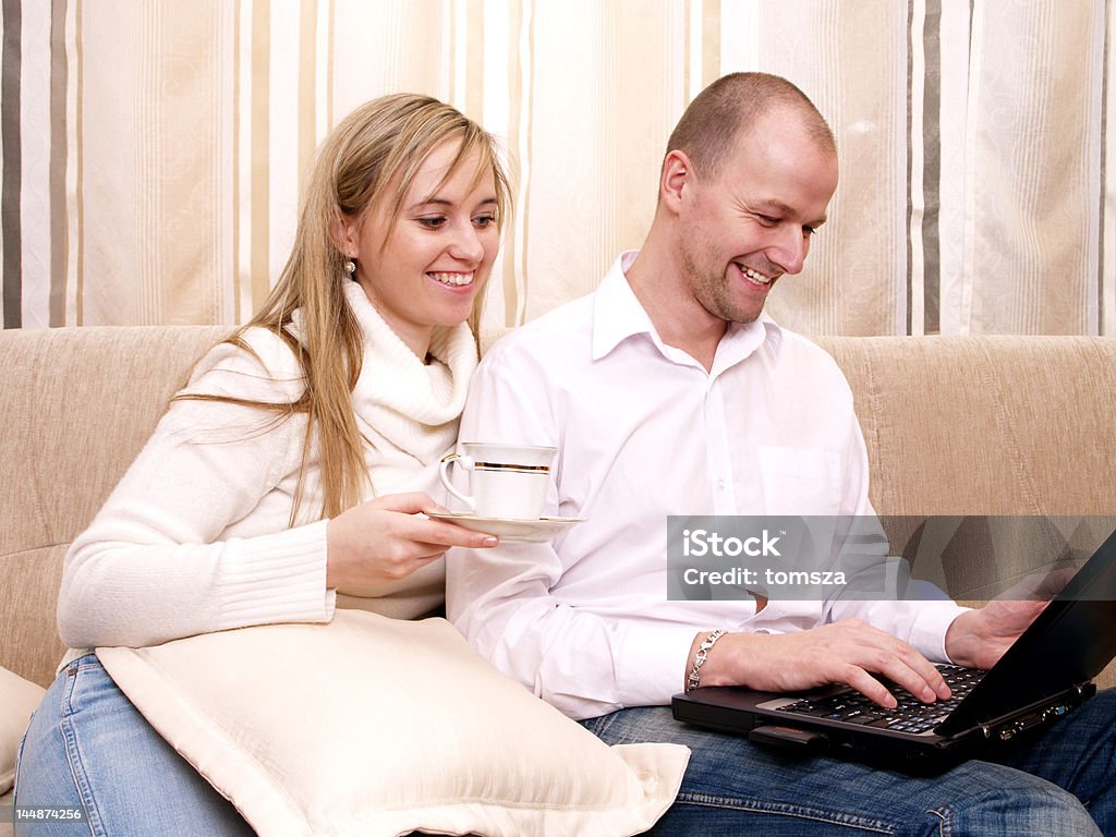 Couple with notebooks Couple with notebooks on a couch Adult Stock Photo