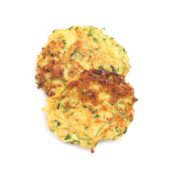 istock Delicious zucchini fritters on white background, top view 1448744578