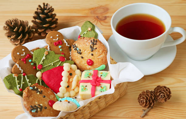 Closeup a Basket of Christmas Cookies and a Cup of Hot Tea on Wooden Table Closeup a Basket of Christmas Cookies and a Cup of Hot Tea on Wooden Table Rich Tea Biscuit stock pictures, royalty-free photos & images