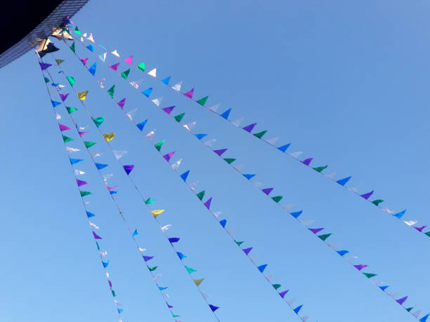 istock Colorful triangular bunting flags waving on the blue sky outdoors. Pennants of various colors fluttered in the sky. Abstract festive background, outdoors 1448746470
