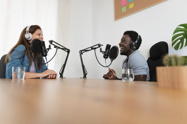 istock Multiracial people recording a podcast using microphone and headphones from home studio 1448746613