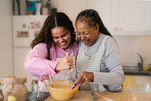 glückliche afrikanische mutter und tochter haben spaß bei der zubereitung eines hausgemachten desserts - grandmother cooking baking family stock-fotos und bilder