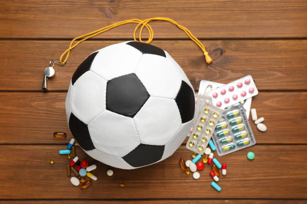 Soccer ball, whistle and different pills on wooden table, flat lay. Doping concept Soccer ball, whistle and different pills on wooden table, flat lay. Doping concept anti doping stock pictures, royalty-free photos & images