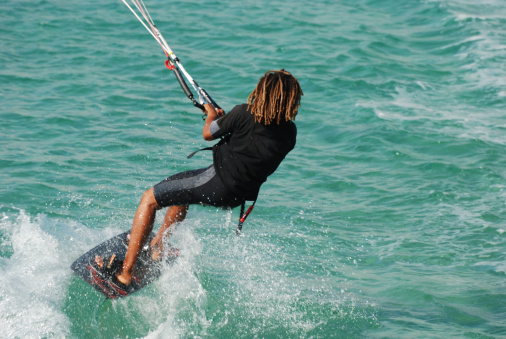 Kite surfer with a long hair riding on a kiteboard in Montenegro, Ada Bojana
