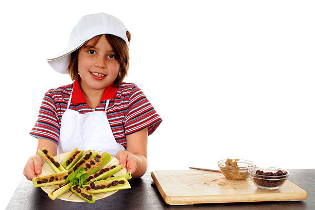 Ants on a Log Mid-elementary girl offering the viewer a plateful of ""ants on a log"" that she made herself -- a fun, nutritious snack. edible ants stock pictures, royalty-free photos & images