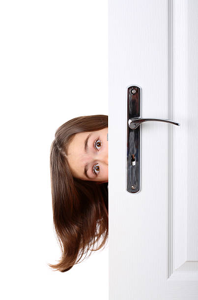 Girl peeking behind the door