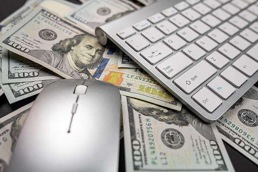 beautiful white computer keyboard on which a large sum of dollars is laid out close by limply isolated. internet income Quick money