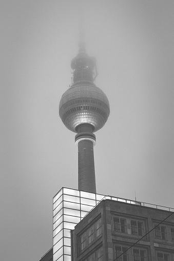 Berlin Television Tower covered in foggy cloud condition.