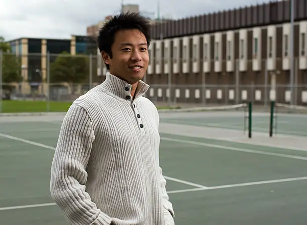 a boy was standing in tennis court