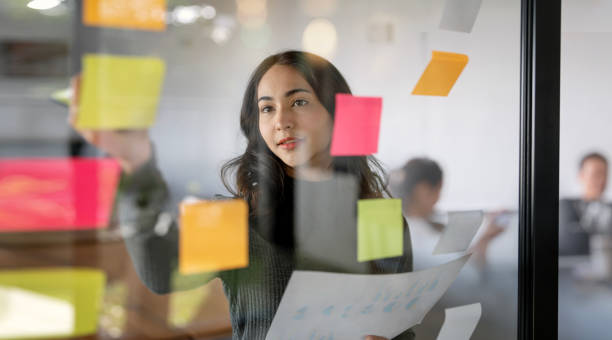 istock Young confident Businesswoman planning with adhesive notes in creative office. 1448764473