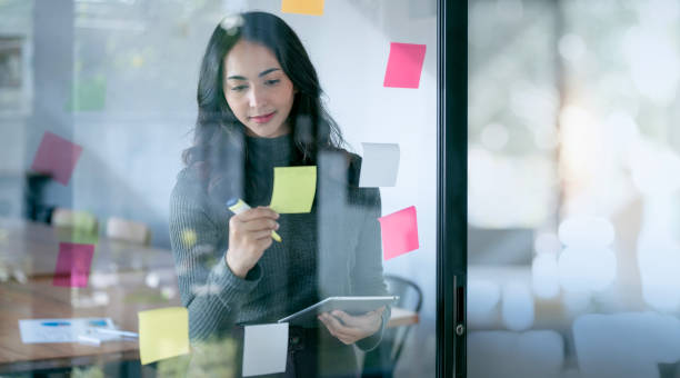istock Young confident Businesswoman planning with adhesive notes in creative office. 1448764768