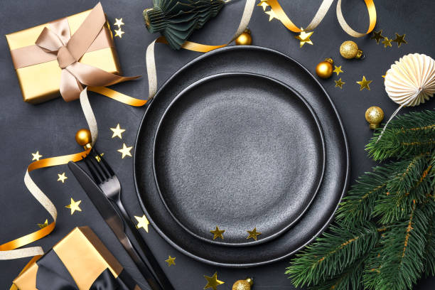 istock Christmas table with black plate, golden gift box and holiday decorations. top view copy space 1448765211