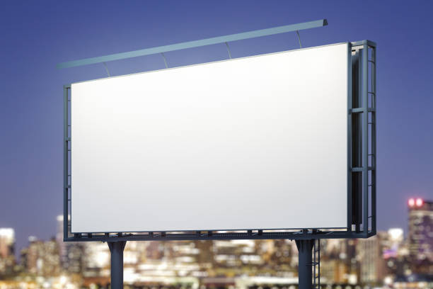 istock Blank white billboard on city buildings background at night, perspective view. Mockup, advertising concept 1448765284