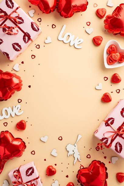valentine's day concept. top view vertical photo of gift boxes heart shaped balloons candies inscription love cupid silhouette confetti on isolated pastel beige background with copyspace in the middle - valentines day candy chocolate candy heart shape imagens e fotografias de stock