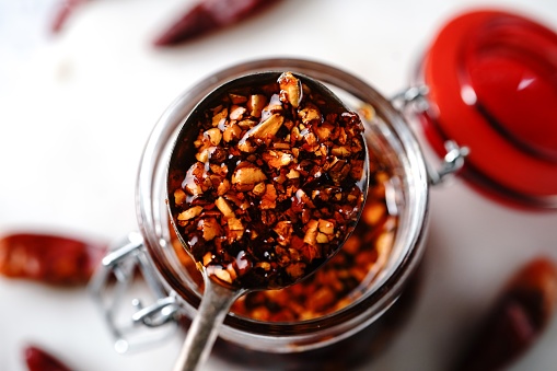 Homemade Asian chilli oil in a glass jar, selective focus