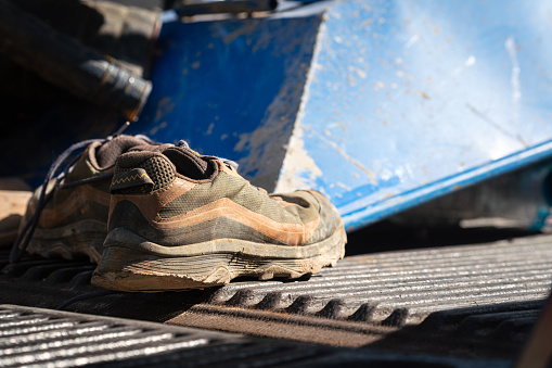 A safety shoe PPE for construction builder worker which is placed on the pick-up truck. Industrial safety workwear object photo, selective focus.