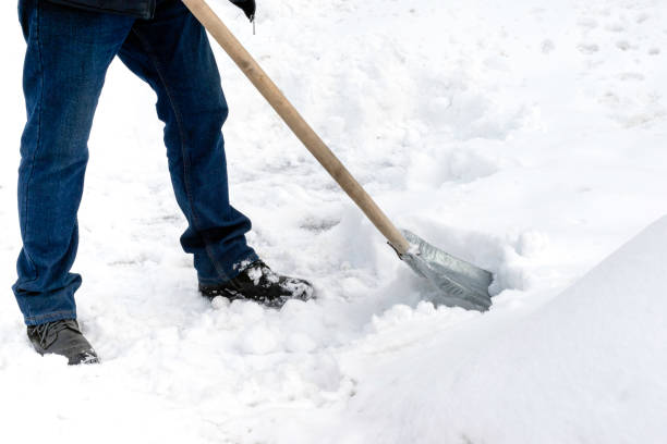 istock A man cleans snow with a metal shovel 1448774396