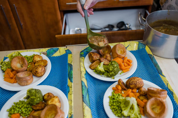 A close-up shot of two trays with of roast dinners on plates, ready to be served to people visiting a warm hub/food bank which is a safe place for people to enjoy a warm and friendly environment in the community with the current cost of living increasing.