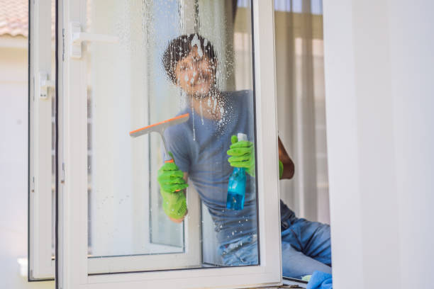 istock A young man cleaning the window with a window cleaner 1448775091