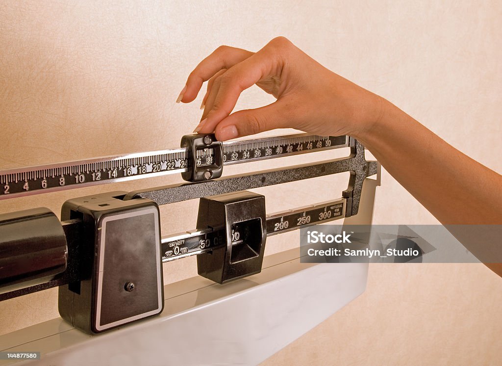 Medical Scales Woman checking her weight. Health Club Stock Photo