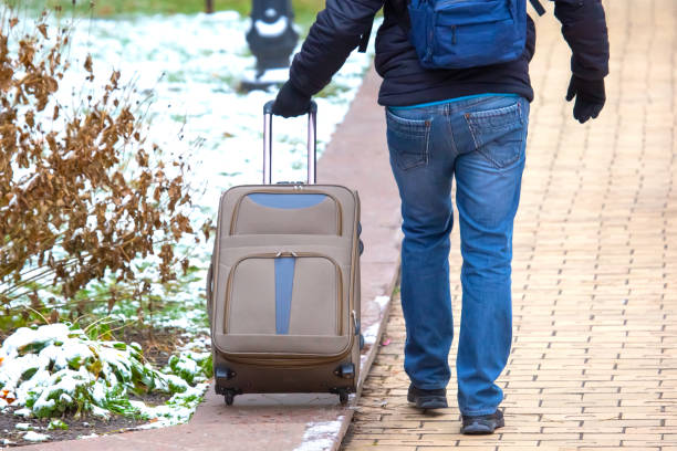 istock man walking down the sidewalk with a luggage bag 1448778249