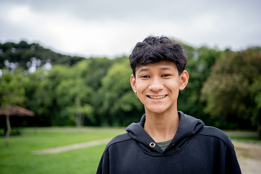 Caucasian teenager boy smiling outdoors in park