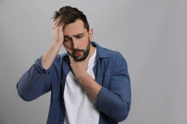 istock Man suffering from sore throat on grey background. Cold symptoms 1448779166