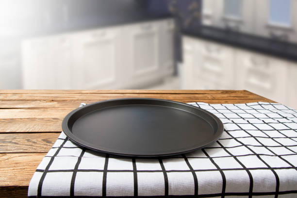 Baking dish. Plaid tablecloth on brown wooden table. Kitchen blured background. Mock up and top view. Copy space, empty place for food. Thanksgiving day. Pie dessert clean bakery form. Selective focus plato para hornear. mantel a cuadros sobre mesa de madera marrón. fondo borroso de la cocina. maqueta y vista superior. espacio de copia, lugar vacío para la comida. día de acción de gracias. postre de pastel limpio forma de panadería. enfoque selecti