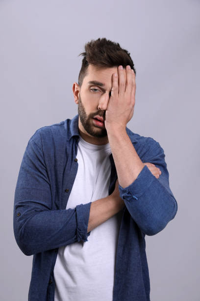 istock Man suffering from headache on grey background. Cold symptoms 1448780597