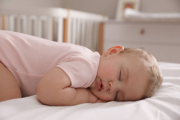 istock Adorable little baby sleeping on bed at home 1448781221