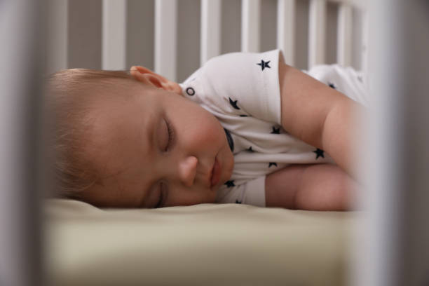 istock Adorable little baby sleeping in crib, closeup 1448781263