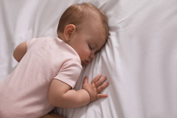 istock Adorable little baby sleeping on bed, above view. Space for text 1448781295