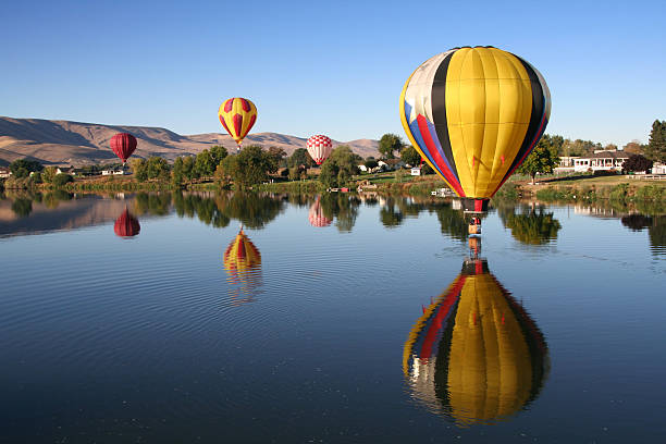 Hot air balloons floating over a river stock photo