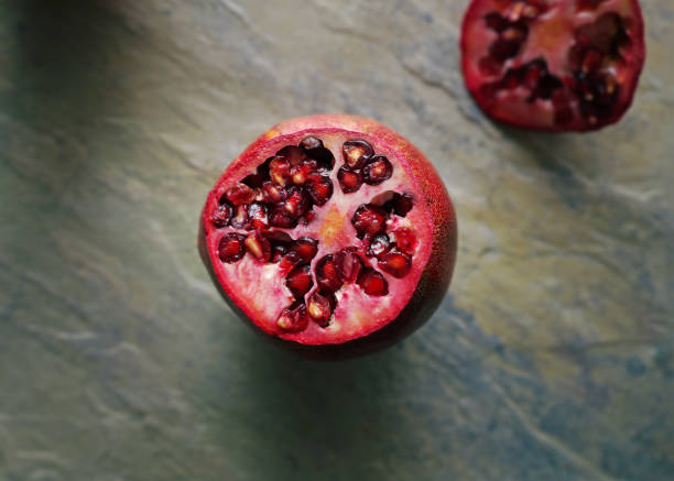 Top flat lay view of a sliced pomegranate showing the seeds and pulp