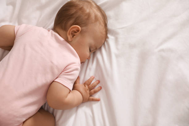 istock Adorable little baby sleeping on bed, top view. Space for text 1448786557