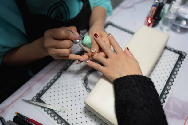 istock Manicurist doing manicure to client closeup 1448787751