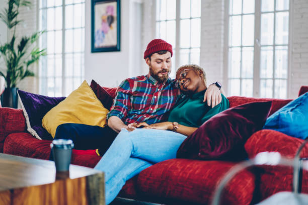 istock Caucasian man talking with African American girlfriend dreaming about future life while resting on comfortable couch in trendy flat, multiracial couple in love enjoying romance relaxing on sofa 1448789206