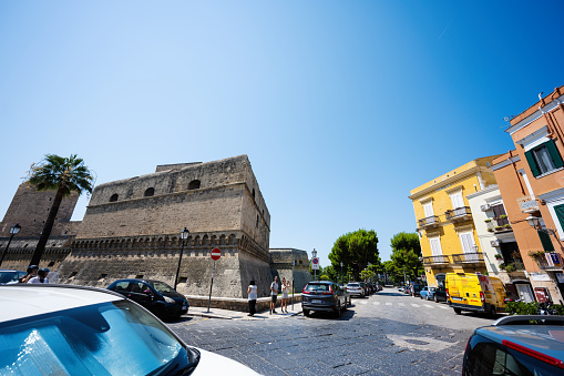 Bari, Italy - Jule 19, 2022: Lots of tightly parked cars near Swabian castle or Castello Svevo, a medieval landmark of Apulia.