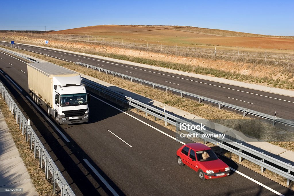 Ładunku ciężarówek i samochodów na autostradzie - Zbiór zdjęć royalty-free (Biały)