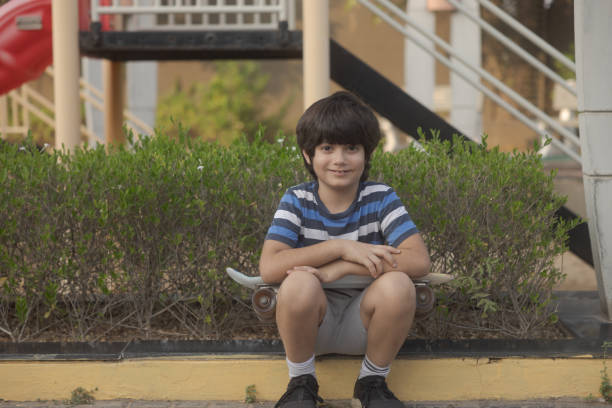 Mixed race (Indian-Iranian) 8 year old playing with his skateboard, active lifestyle