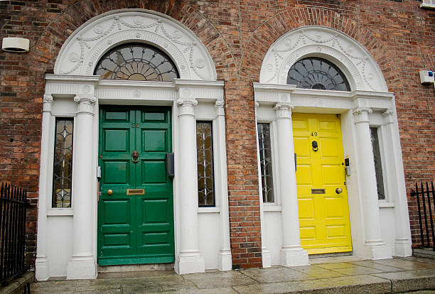 Woman walks past colorful doors in the North Georgian Quarter of downtown Dublin, Ireland on a cloudy day.