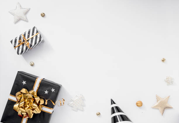 istock Gift or present box, party hats and stars on white table. Christmas composition with black and golden decorations 1448801767