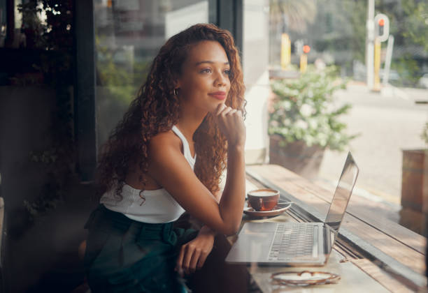 Cafe, laptop and relax student girl on study break for peace, wellness and calm while working on research project. Coffee shop, glass window and black woman thinking of copywriting inspiration idea