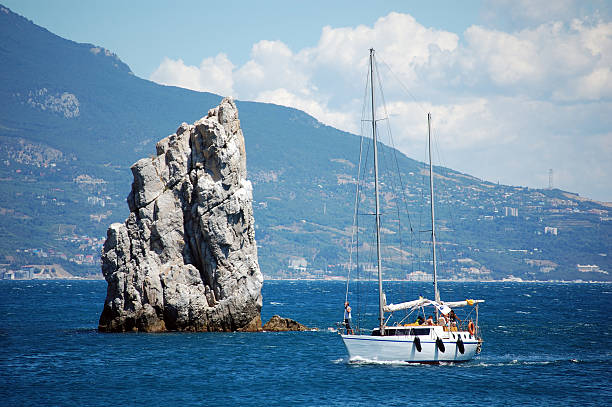 Sailing vessel and rock stock photo