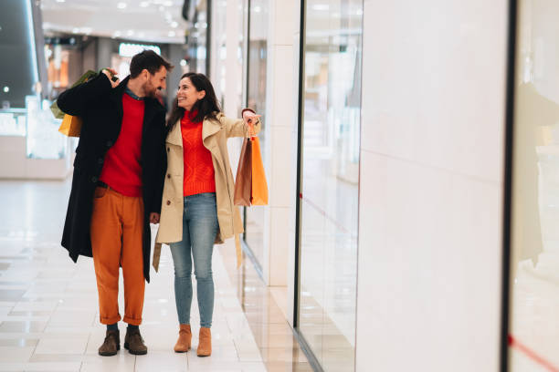istock Romantic couple looking at each other while walking through a shopping mall 1448807081