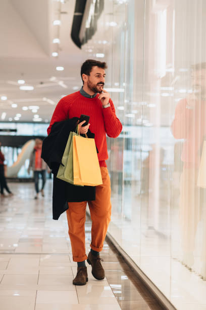 istock Young man Christmas shopping in a mall 1448807709