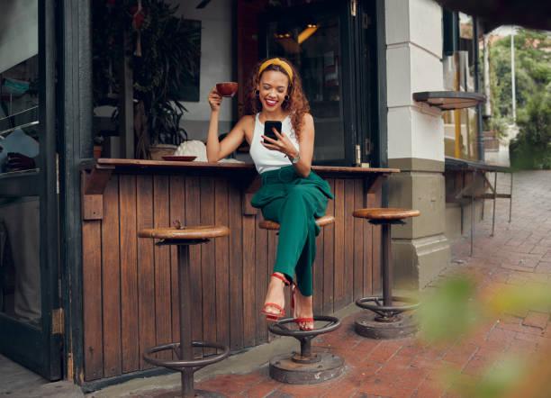 telefon, social media und kaffee mit einer schwarzen kundin an einem café-tresen auf dem bürgersteig. café, internet und kommunikation mit einer jungen frau, die in einem restaurant eine sms tippt - sidewalk cafe stock-fotos und bilder